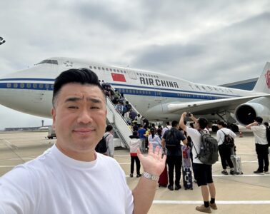 a man taking a selfie with a plane in the background