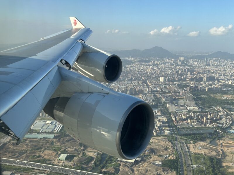 an airplane wing with two engines above a city