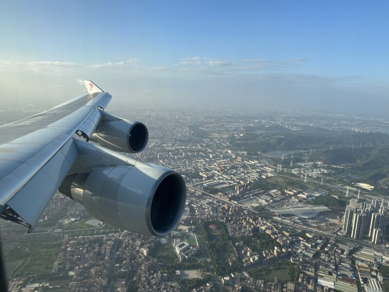 an airplane wing with two engines above a city