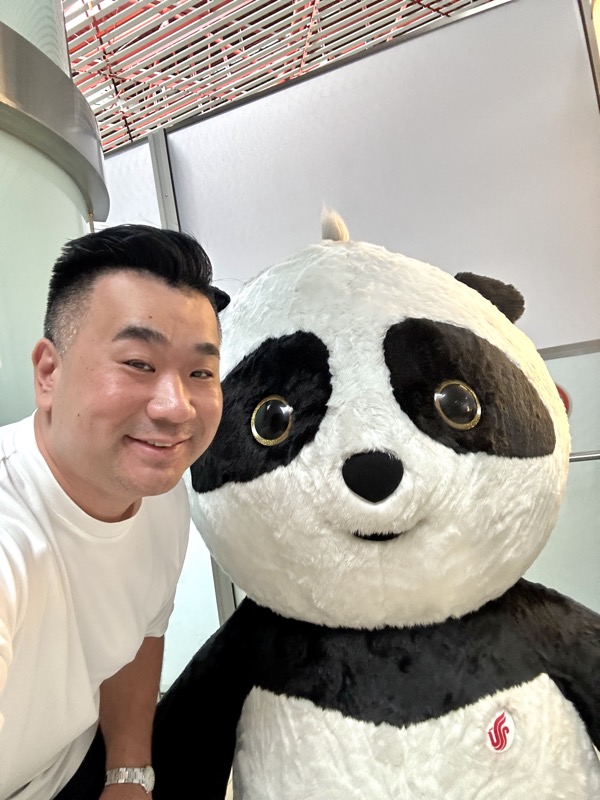 a man taking a selfie with a giant panda bear