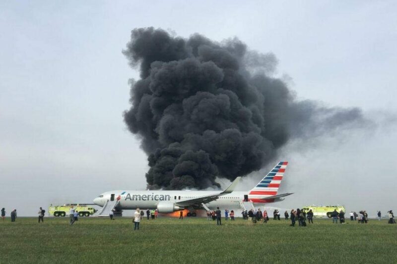a plane on the runway with black smoke
