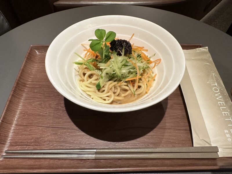 a bowl of noodles and vegetables on a tray