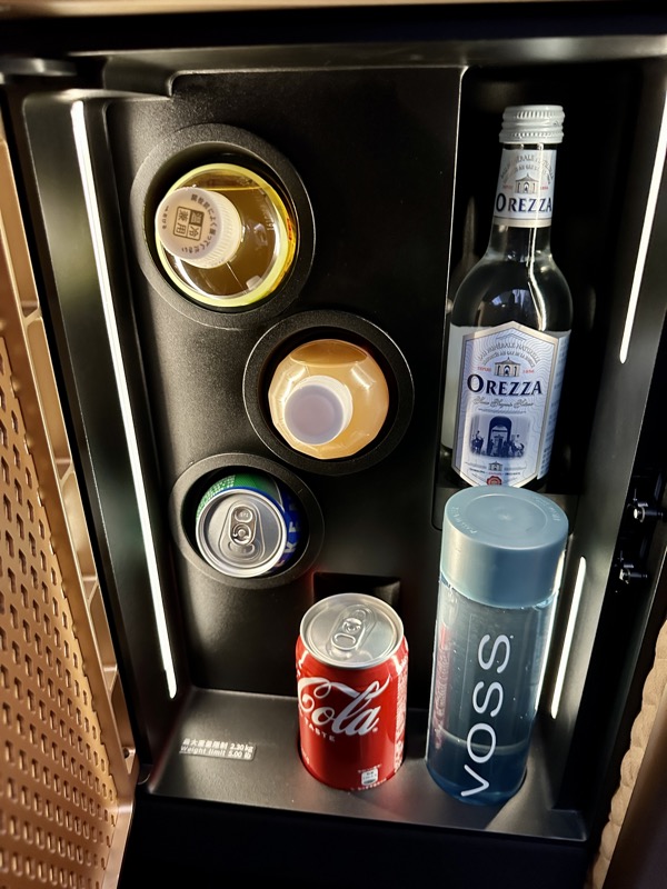 a mini fridge with bottles and cans of soda