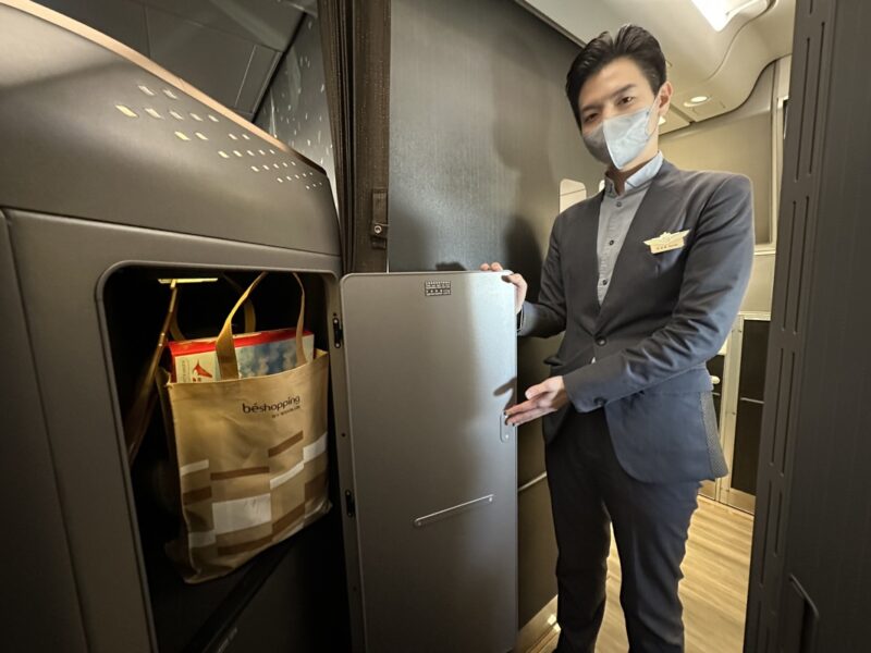a man wearing a mask and standing in a room with a refrigerator