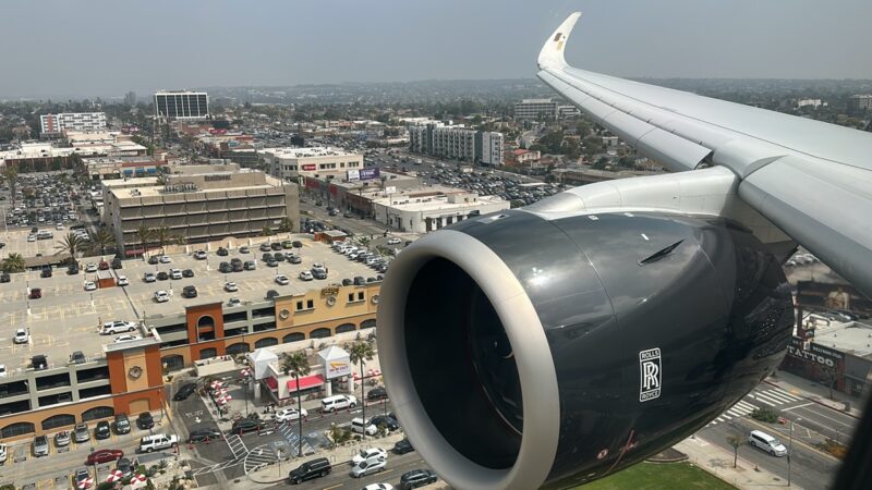 an airplane wing and engine above a city